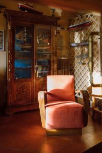 a living room with a chair and a cabinet at Albergo La Felicina - Mugello in San Piero a Sieve