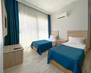 a hotel room with two beds and a window at eYLÜL 16 OTEL in Çeşme