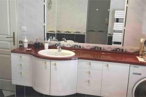 uma casa de banho com um lavatório e um espelho grande em VILLA LES PIEDS DANS L’EAU ACCES DIRECT A LA PLAGE em Le Plomb