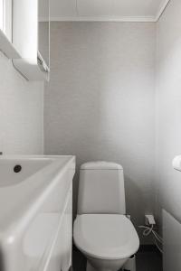 een witte badkamer met een toilet en een wastafel bij Gulliga torpet in Vislanda