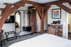 a bedroom with a bed and a mirror at Central Park Voorburg - Relais & Chateaux in Voorburg