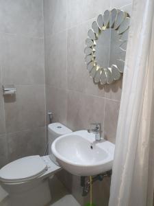 a bathroom with a toilet and a sink and a mirror at Lenggo - Apartement Meisterstadt Pollux Habibie 52-05 in Kangboi