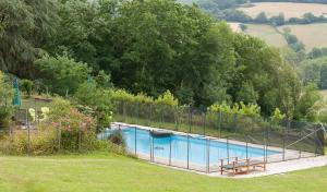 une piscine entourée d'une clôture dans l'établissement Château pour se retrouver, à Larochemillay