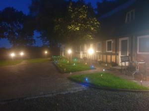 a house with lights in the yard at night at Cozy Hideaway - Rustic Charm & Outdoor Adventure 1 in Hornsyld