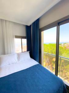 a bedroom with a bed and a large window at eYLÜL 16 OTEL in Çeşme +33 photos