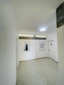 ein großes weißes Zimmer mit Gemälden an den Wänden in der Unterkunft Hotel Villa Ferrari in Tirana