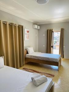 una camera con due letti e una finestra di Hotel Villa Ferrari a Tirana