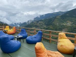 een balkon met blauwe en oranje bonenzakken en uitzicht op de bergen bij Yamaç Çam Hotel in Trabzon