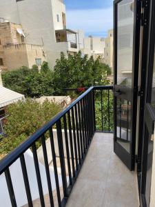 a balcony with a door and a view of the ocean at Gzira Centre Apartment in Il-Gżira