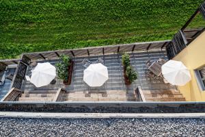 einen Blick über eine Terrasse mit Tischen und Sonnenschirmen in der Unterkunft Apartmenthotel 's Mitterndorf in Traunkirchen