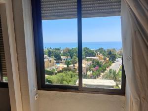 a window with a view of a street and the ocean at El Paraiso in Aguadulce