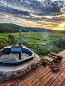 a hot tub on a deck with a view of a field at House on the Hill in Heidelberg