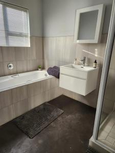 een badkamer met een bad, een wastafel en een bad bij House on the Hill in Heidelberg