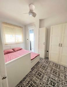 sypialnia z łóżkiem z różową pościelą i oknem w obiekcie Cozy apartment La Mata w mieście La Mata +8 zdjęć