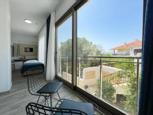 a room with a balcony with chairs and a large window at eYLÜL 16 OTEL in Çeşme