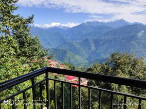 a balcony with a view of a mountain range at Hotel Hidden House (Fair View) in Pelling
