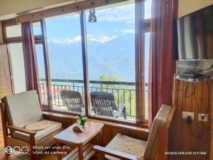 a room with a balcony with a view of mountains at Hotel Hidden House (Fair View) in Pelling