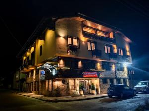 班斯科的住宿－Bansko Boutique Hotel，一座建筑,晚上停在前面