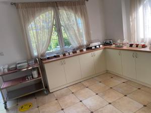 a kitchen with white cabinets and a window at Perla Beach in Agia Marina Nea Kydonias