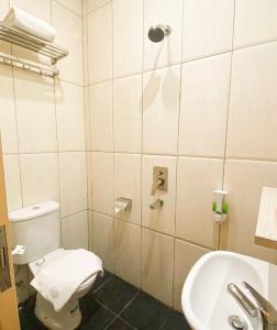 a bathroom with a toilet and a sink at Front One Cabin Sunter in Jakarta