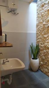 a bathroom with a sink and a plant in a vase at Nako Tropical House 2BR at Bali Bukit Uluwatu - Ungasan in Uluwatu