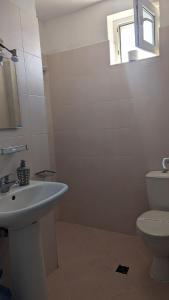 a bathroom with a sink and a toilet and a window at Guest House Chalakov in Sinemorets