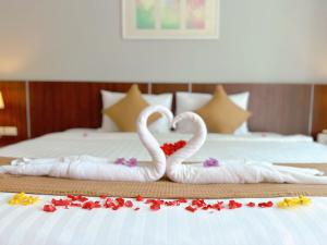 twee zwanen gemaakt om eruit te zien als harten zittend op een bed bij Ahad Suite Ao Nang By Ma in Ao Nang Beach
