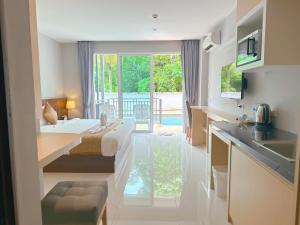 uma cozinha com uma cama e um lavatório num quarto em Ahad Suite Ao Nang By Ma em Praia de Aonang