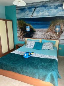 a bedroom with a bed with a painting of a beach at Guest House Chalakov in Sinemorets