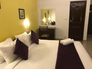 1 dormitorio con 1 cama blanca grande con almohadas en North Centre, en Kochi