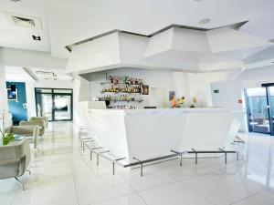 - un hall blanc avec un bar et des chaises dans l'établissement VacationClub - Arka Apartament 330, à Kołobrzeg