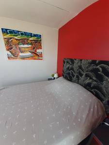 a bedroom with a bed and a painting on the wall at Chambre d'hôte près de Paris in Épinay-sur-Seine