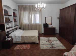 1 dormitorio con cama y lámpara de araña en Casa tra le vigne, en Mombercelli
