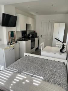 a kitchen with white cabinets and a black and white table at Modern Comfy One Bed Apartment - Free Parking in Glasgow