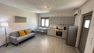 a living room with a couch and a kitchen at Harihara Guesthouse near Airport in Paianía