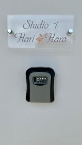 un termostato en una pared con una señal. en Harihara Guesthouse en Paianía