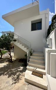 uma escada que leva a uma casa branca com uma janela em Harihara Guesthouse em Paianía