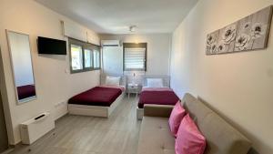 uma sala de estar com duas camas e um sofá em Harihara Guesthouse em Paianía