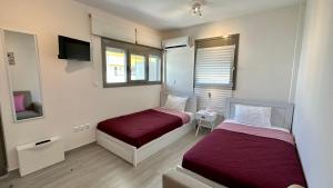 Habitación de hotel con 2 camas y TV en Harihara Guesthouse en Paianía