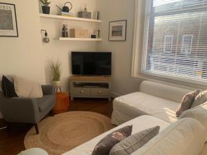 a living room with a couch and a tv at Abbey and Clock Tower view in Saint Albans