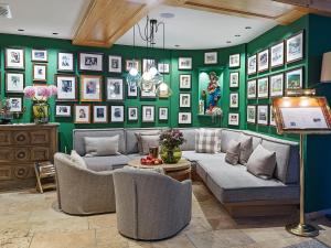 a living room with a green wall with pictures at Der Unterschwarzachhof in Saalbach Hinterglemm