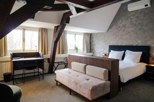 a bedroom with a bed and a desk and a piano at Central Park Voorburg - Relais & Chateaux in Voorburg