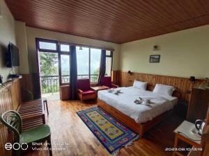 a bedroom with a bed and a large window at Hotel Hidden House (Fair View) in Pelling