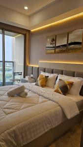 a large white bed in a room with a window at Studio Sea View Apartment at Gold Coast PIK by MYsweethome in Jakarta