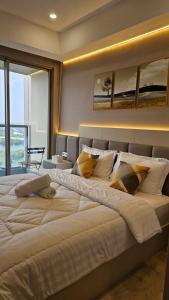 a large white bed in a room with a window at Studio Apartment at Gold Coast PIK in Jakarta