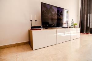 a large white entertainment center with a large television on it at Mambo Palm-Mar apartment in Palm-Mar