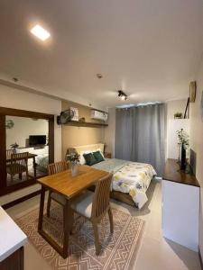 Cet appartement comprend une chambre avec un lit et une table ainsi qu'une cuisine. dans l'établissement Ohana Suites Lapu-Lapu City Condo Staycation Near Mactan International Airport, à Lapu Lapu City