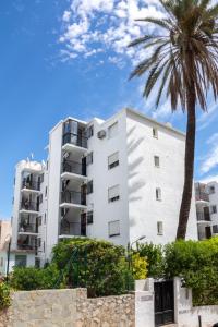 Biały budynek z palmą przed nim w obiekcie Casa Anselmsson - Your Dream Duplex Escape with a pool w mieście Torremolinos