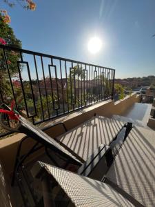 un balcone con tavolo, sedie e recinzione di Cubana Resort Appartement loopafstand Mambo beach a Willemstad