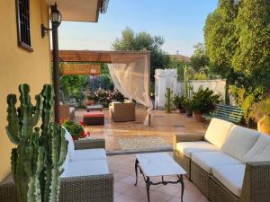 a patio with white couches and a cactus at Villa Sicels - Agnone Beach - Syracuse in Agnone Bagni